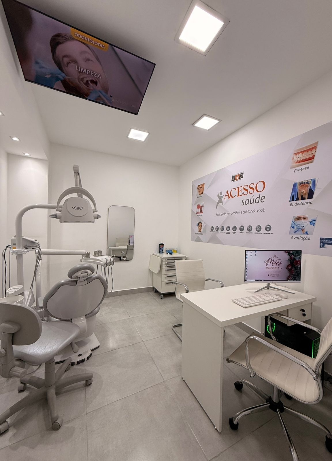 Consultório com TV de teto exibindo procedimentos odontológicos — Acesso Saúde CIC